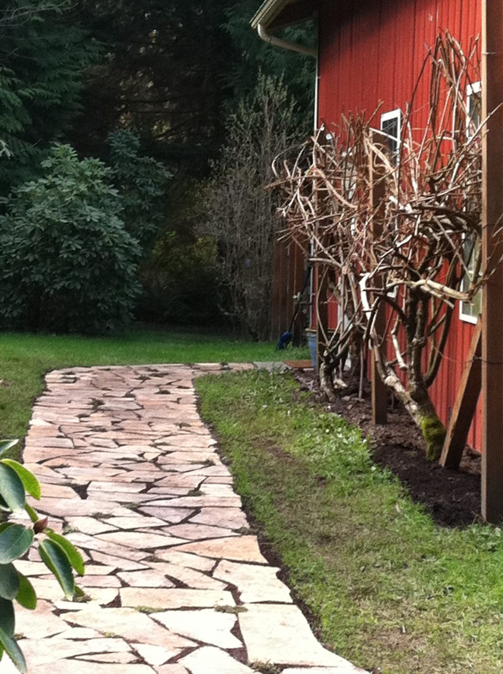 Photo of a stone path leading around a barn