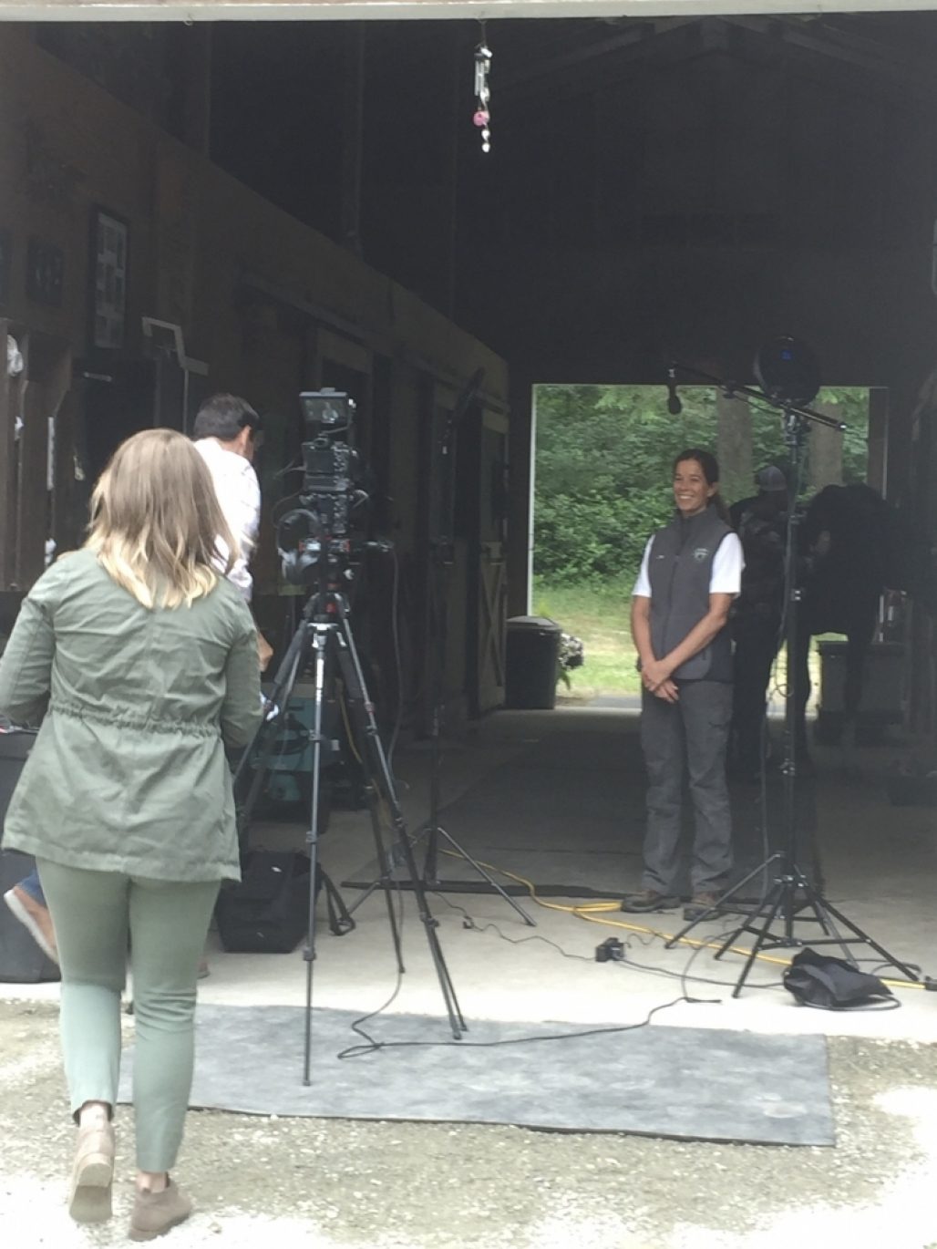 Kim Bauer being filmed in a barn by a film crew